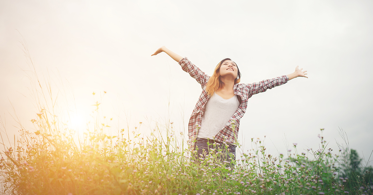 Young beautiful hipster woman in a flower field at sunset. Freed